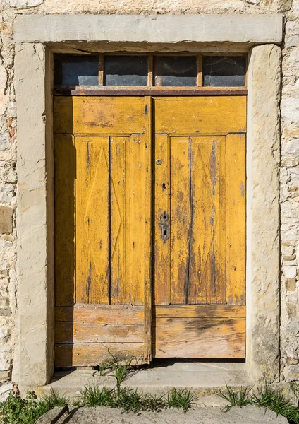 Yellow ragged shabby wooden door — Stock Fotó