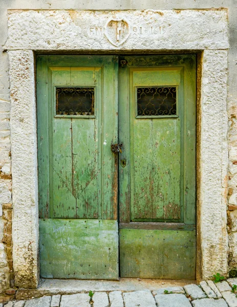 Vieille porte en bois déchiquetée verte avec barres en fer forgé — Photo