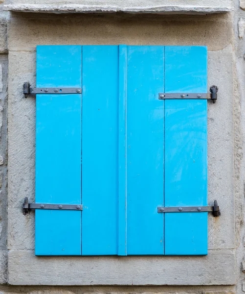 Oude venster met gesloten blauwe houten luiken — Stockfoto