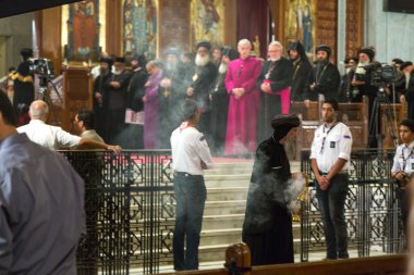 An Orthodox priest burns incense during a sermon clipart