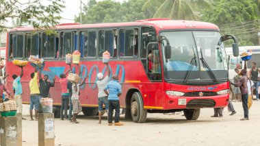 Street vendors selling food to passengers of a bus 