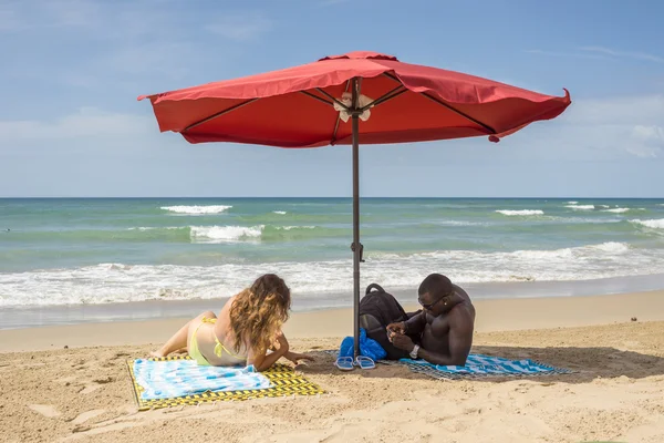 Межрасовая пара наслаждается пляжем — стоковое фото