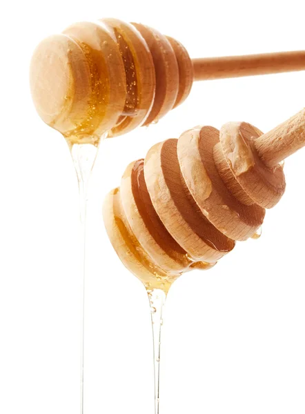 Miel dégoulinant des trempettes au miel en bois — Photo