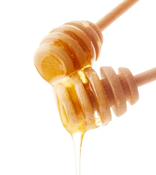 Honey dripping from wooden honey dippers — Stock Photo, Image