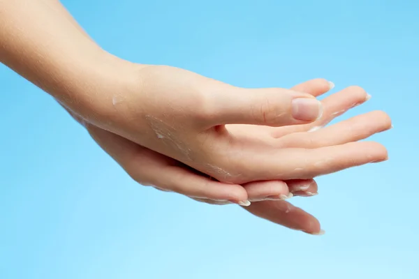Mãos de mulher em creme hidratante — Fotografia de Stock