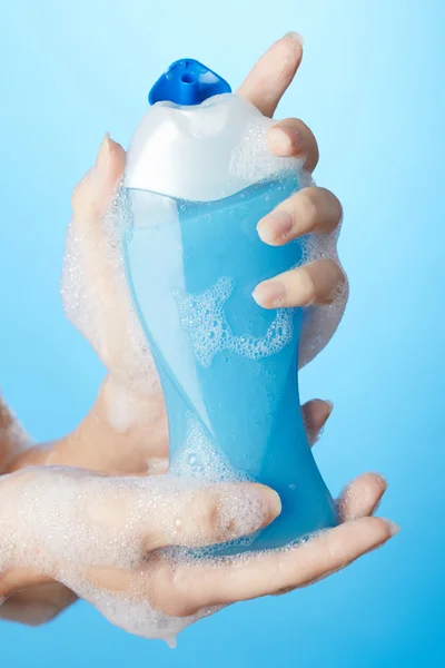 Woman in bathroom with bottle of shower gel in hand — Stock Photo, Image