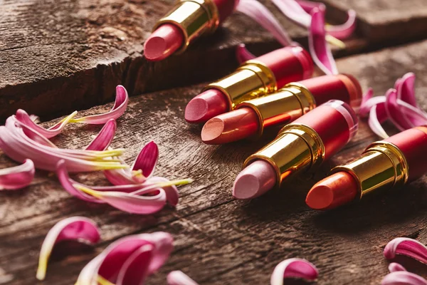 Lipsticks with flower petals — Stock Photo, Image