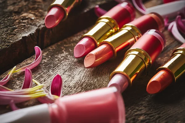 Lipsticks with nail polish and flower petals — Stock Photo, Image