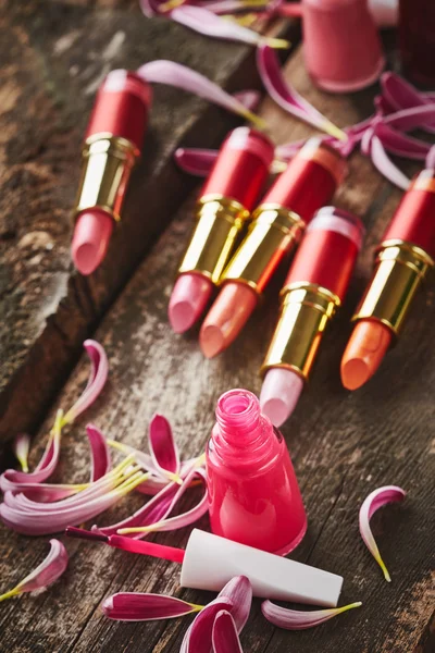 Lippenstifte mit Nagellack und Blütenblättern — Stockfoto