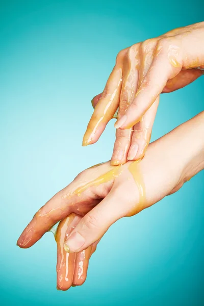 Woman's hands in honey — Stock Photo, Image