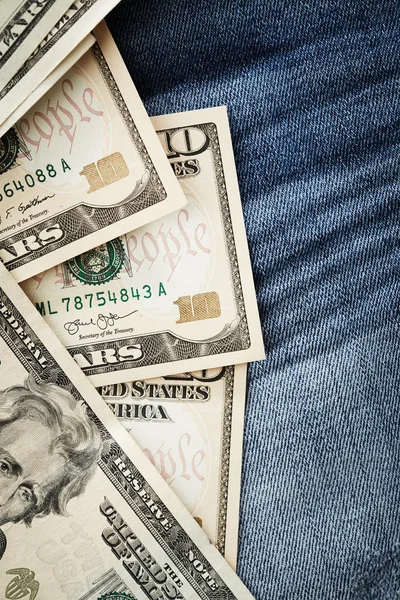 Доллары на фоне джинсов — стоковое фото