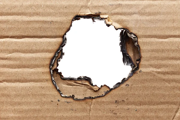 Burnt hole in cardboard — Stock Photo, Image