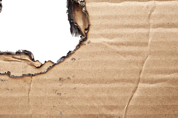 Burnt hole in cardboard — Stock Photo, Image