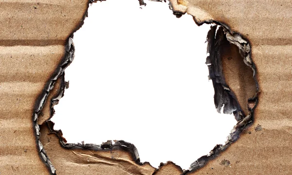 Burnt hole in cardboard — Stock Photo, Image