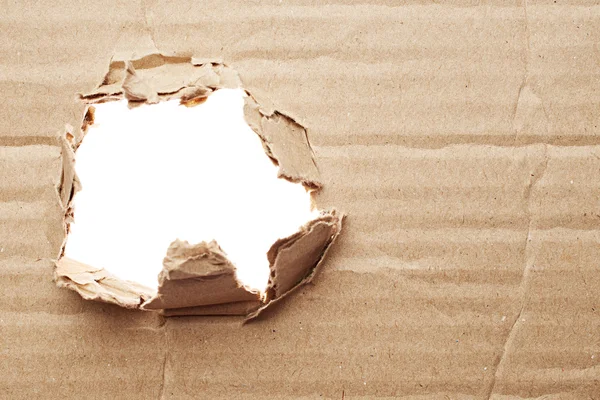 Torn hole in cardboard — Stock Photo, Image