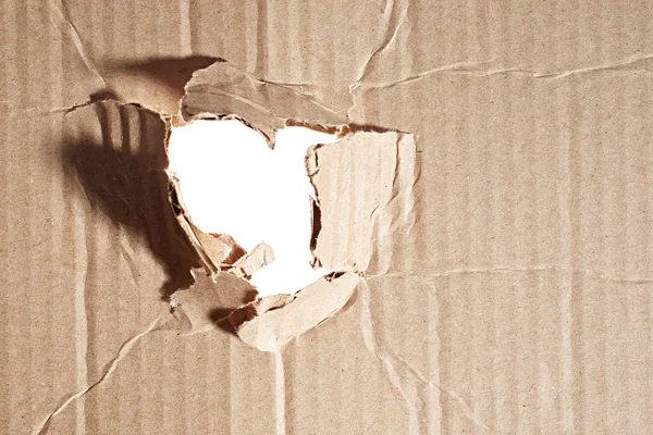 Torn hole in cardboard — Stock Photo, Image