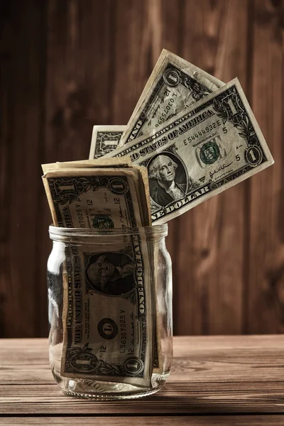 Сбережения. Доллары в стеклянной банке — стоковое фото