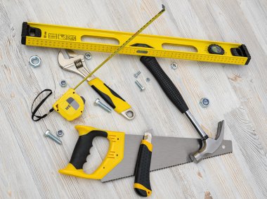 Ahşap DIY tezgah üzerinde üstten görünüm İnşaat aletleri ve araçları. Düzeyi, testere, şerit metre, İngiliz anahtarı, çekiç, kesici.