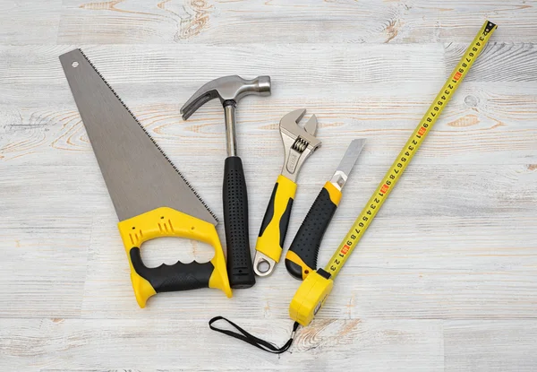 The top view of different working tools lying on wooden workbench — Stock Photo, Image