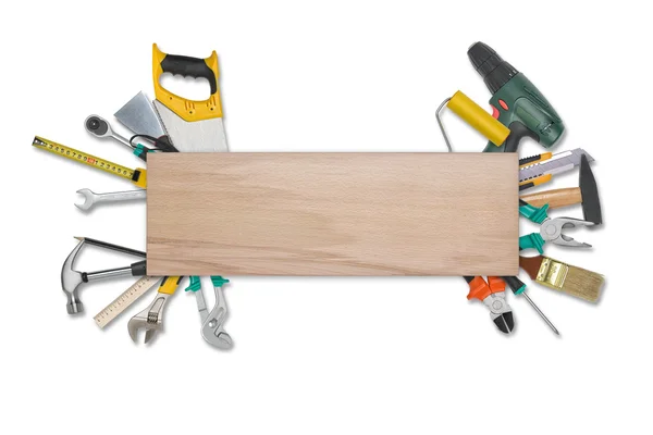 Set di strumenti di costruzione dietro tavolato di legnoisolato su uno sfondo bianco. Sega, occhiali, metro a nastro, chiave, chiave inglese, rullo di vernice, martello, taglierina, pinze . — Foto Stock