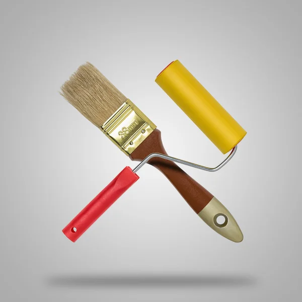 Crossed brush and roller paint on gray background like icon — Stock Photo, Image