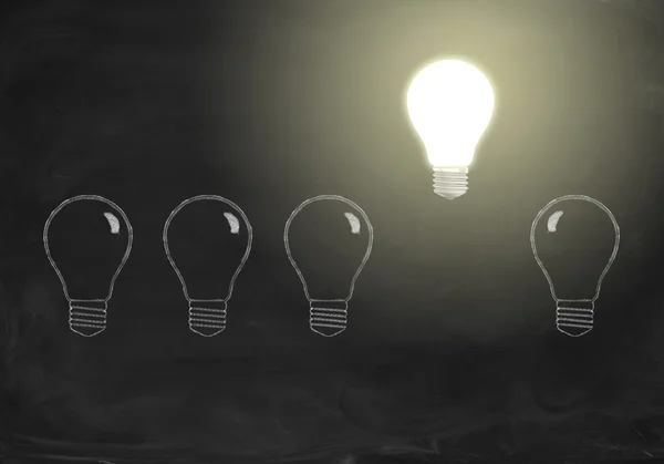 Shining realistic bulb in row with drawing bulbs on chalkboard. Idea concept — Φωτογραφία Αρχείου