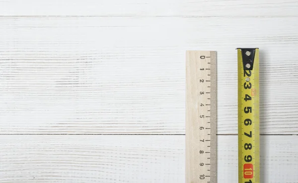 Widok z góry taśmy miara i linijka na białym drewnianym warsztacie DIY. — Zdjęcie stockowe