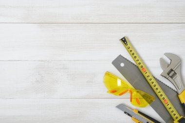 Ahşap DIY tezgah üzerinde üstten görünüm İnşaat aletleri ve araçları. Açık alan ile. Düzeyi, mezura, İngiliz anahtarı, kesici.