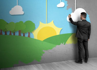 Beton duvara doğa çizen insanın arka görünümü