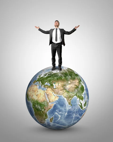 Hombre de negocios levantando sus manos al cielo de pie en el globo terráqueo. Elementos de esta imagen son proporcionados por la NASA —  Fotos de Stock