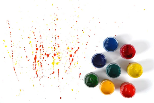 Gouache jars on a white background with colorful spray in top view — Stock Photo, Image