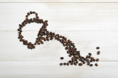 Top view coffee beans making shape of mug from which pours a drink clipart