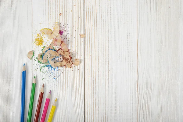 Colocación plana de diferentes lápices de colores y virutas en la mesa — Foto de Stock