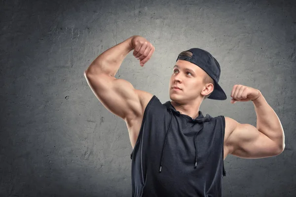 Retrato de jovem homem musculoso flexionando o bíceps — Fotografia de Stock