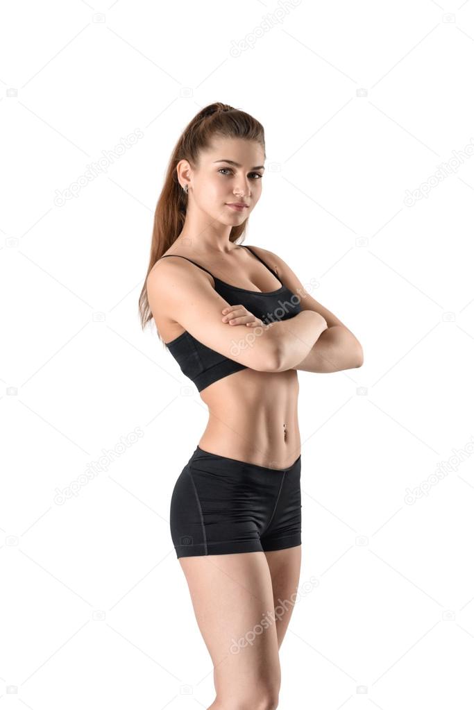 Cutout fitness woman in shorts and a tank top standing sideways with her  arms folded Stock Photo by ©gearstd 106519872