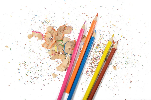 Επίπεδη θέσει διάφορα χρωματιστά μολύβια και ροκανίδια στο τραπέζι — Φωτογραφία Αρχείου