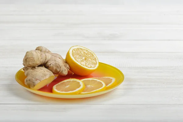 Склад жовтих скибочок лимона та імбиру, викладених на блюдці — стокове фото