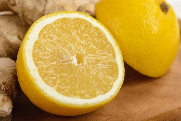 Lemon kuning irisan dan setengah di papan potong — Stok Foto