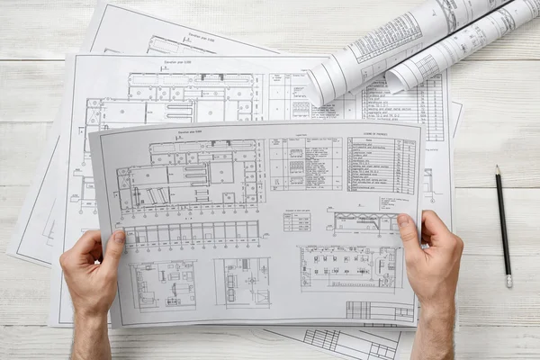 Händerna på arkitekten hålla en ritning skiss. — Stockfoto