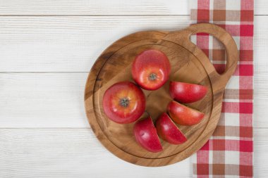 Top görünümünde damalı mutfak masa örtüsü ile ahşap yüzey üzerinde elma..
