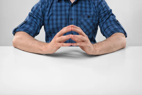 Cropped portrait of a man sitting with his clasped fingers. — Stock Photo, Image