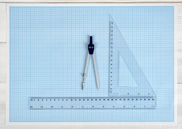 Centimeter rulers and engineering divider on a blueprint.