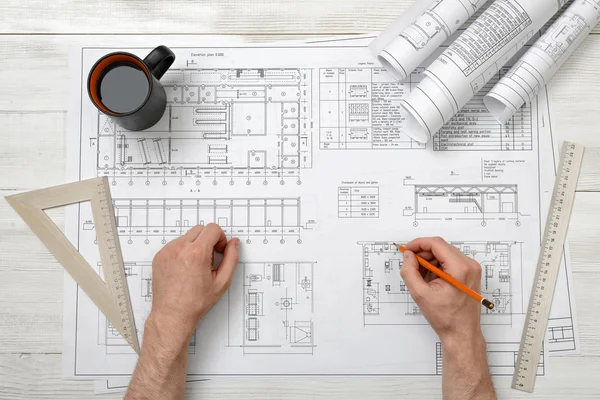 Nahaufnahme der Hände eines Architekten, der mit Bleistift an einer Zeichnung arbeitet — Stockfoto