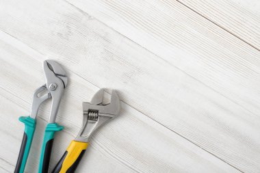 Construction tools placed in the right down corner on wooden surface with open space.