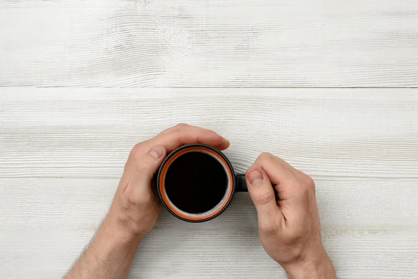 Közelkép kezében ember, aki egy csésze kávé. — Stock Fotó