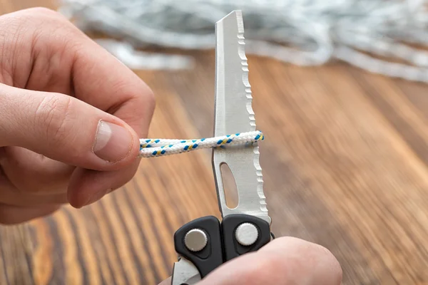 Närbild händer man styckningsdelar repet med många redskap med sågtandade blad. — Stockfoto