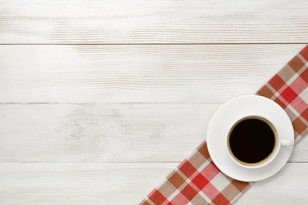 Irodai munkahely csésze kávé a kockás terítő — Stock Fotó