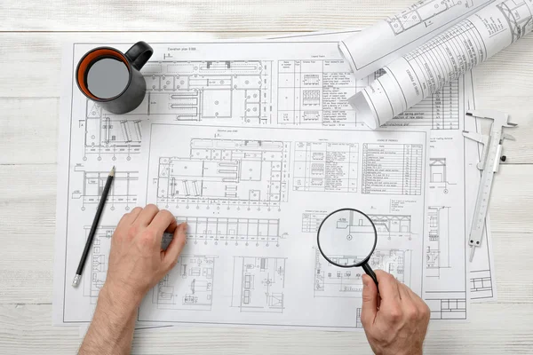 Руки архитектора крупным планом во время работы с лупой — стоковое фото