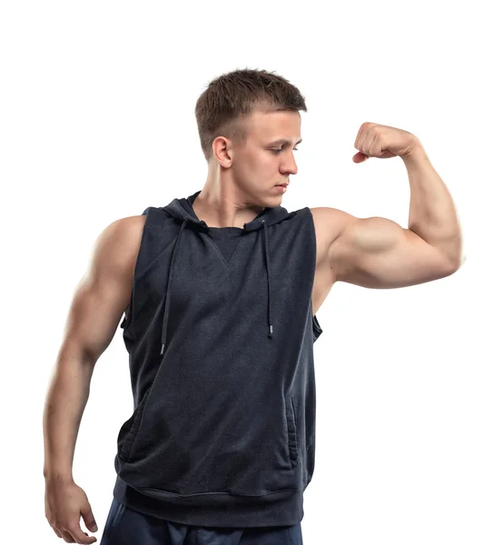 Retrato de sorrir jovem musculoso mostra músculos do braço - bíceps . — Fotografia de Stock