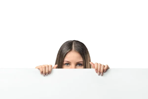 Business woman peeping from behind a white canvas Royalty Free Stock Photos